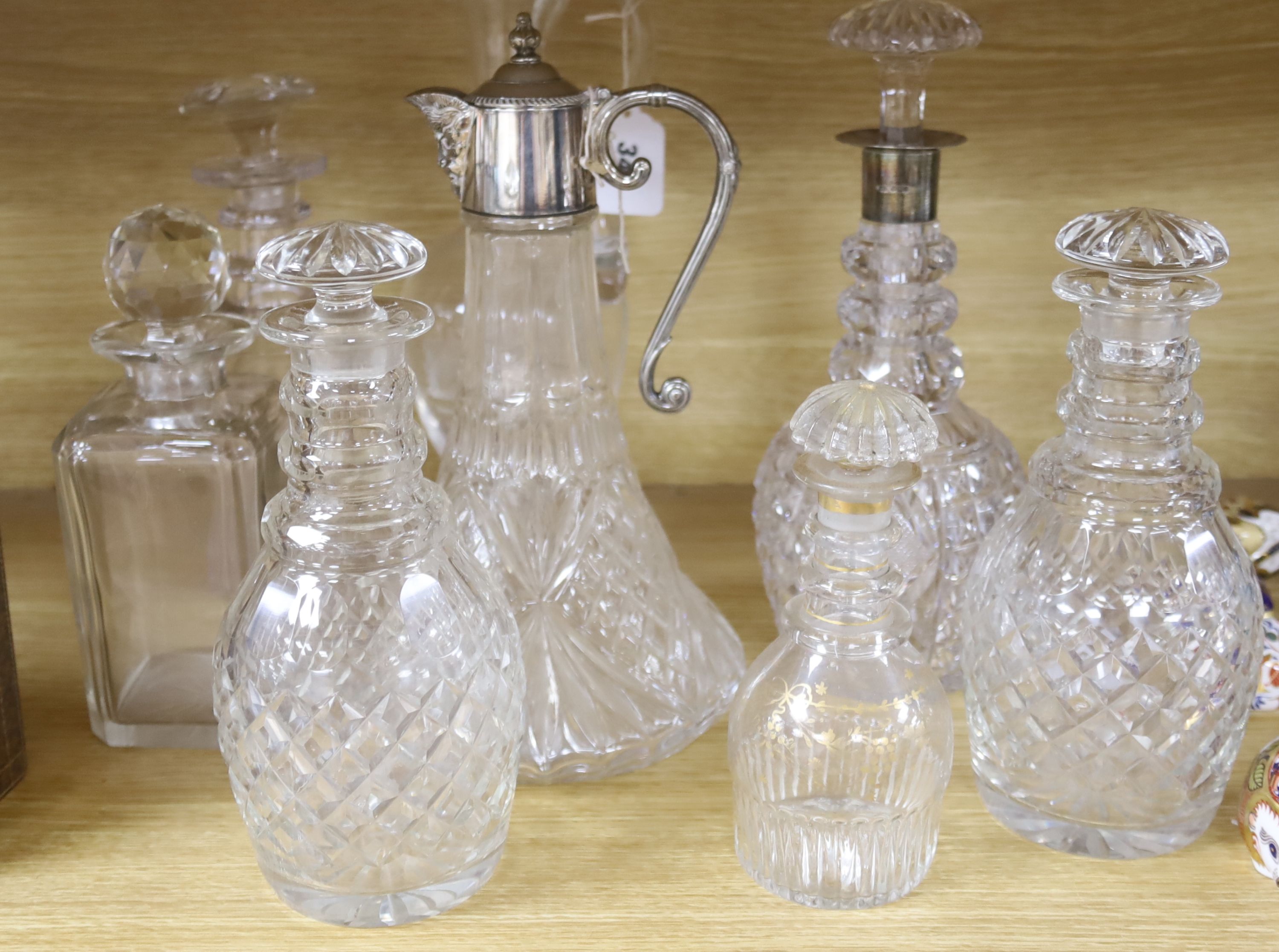 A silver mounted decanter, various other decanters, a claret jug and a jug